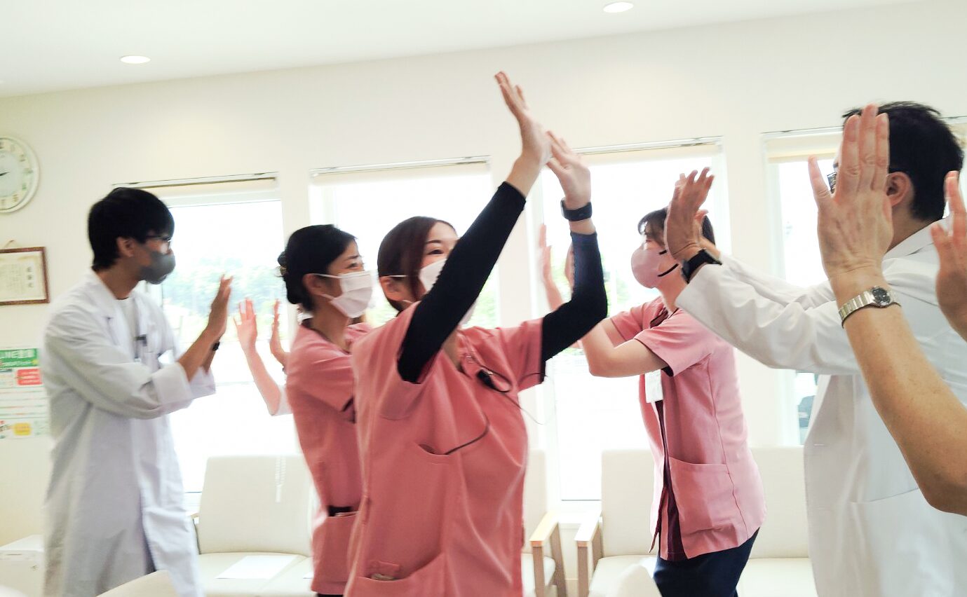 あまが台ファミリークリニックのスタッフの朝礼でのハイタッチの様子